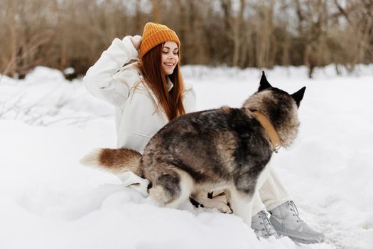 portrait of a woman outdoors in a field in winter walking with a dog Lifestyle. High quality photo