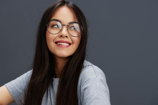 Brunette glasses on face fashion lifestyle gray t-shirt studio model. High quality photo