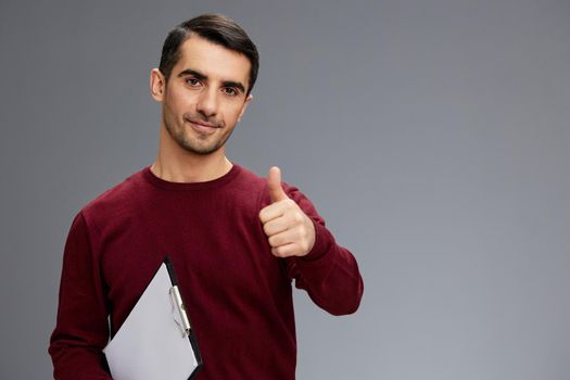 man posing gesture with hands red sweater work Gray background. High quality photo