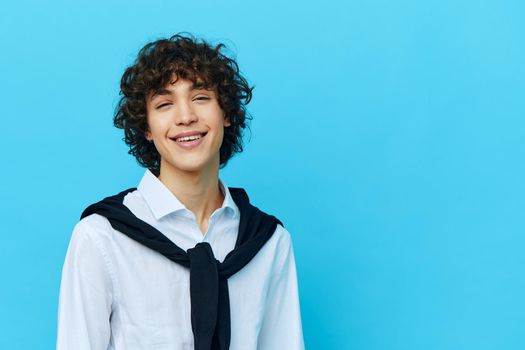 curly guy in a white shirt sweater on the shoulders isolated backgrounds. High quality photo