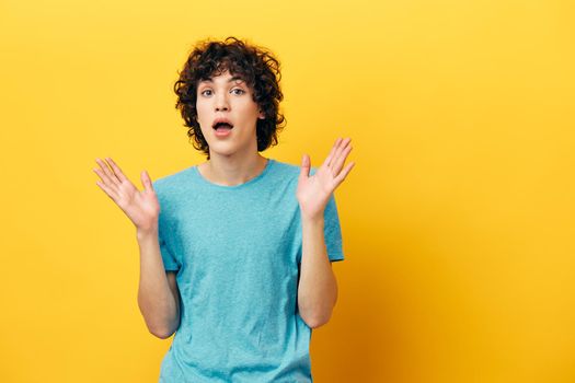 man in blue t-shirt shocked on yellow background. High quality photo