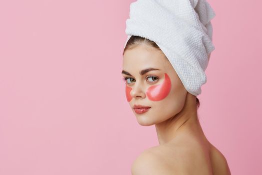 woman pink patches on the face with a towel on the head isolated background. High quality photo