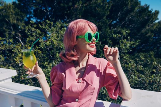 cheerful woman with pink hair summer cocktail refreshing drink Summer day. High quality photo