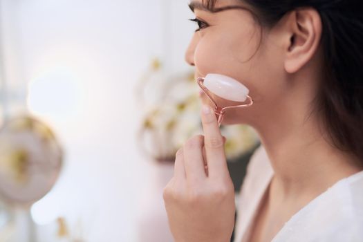 Woman caring of her beauty face with cosmetic tool