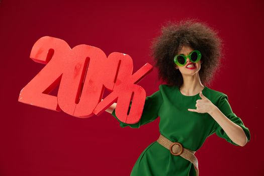 Beauty Fashion woman green dress afro hairstyle dark glasses twenty percent in hands color background unaltered. High quality photo