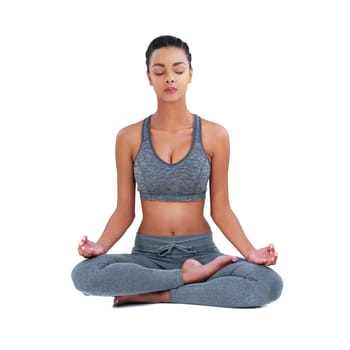 Full length shot of a female athlete meditating against a white background.