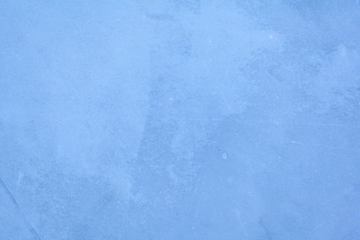 Empty ice rink with skate marks after the session outdoor. skating ice rink texture covered with snow in daylight. Close up of blue ice rink floor, copy space