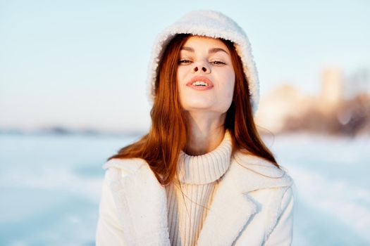 woman in a white coat in a hat winter landscape walk nature. High quality photo