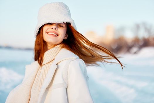 pretty woman in a white coat in a hat winter landscape walk travel. High quality photo