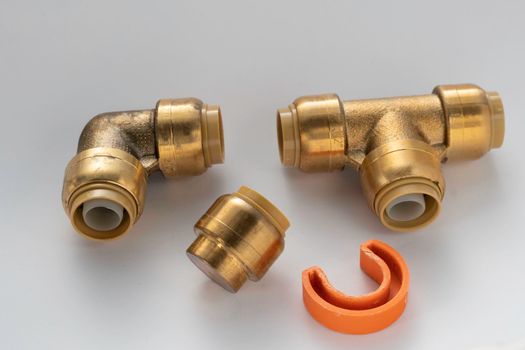 Brass plumbing parts, pipes, elbows, corners and plugs on a white background