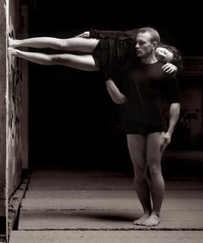 Two Dancers Forming a Body Frame Next to a Wall.