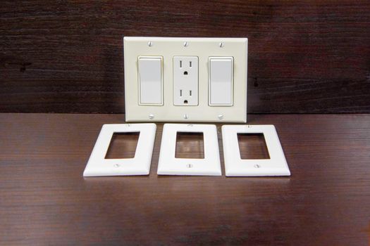 Two switches, a socket and three separate white, decorative, plastic covers for a socket or switch