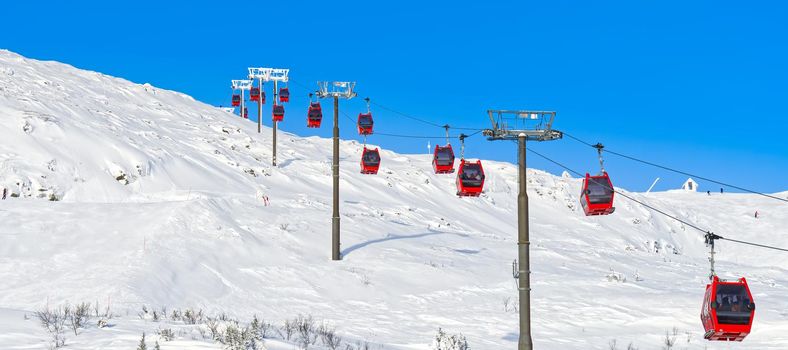 Ski resort in sunny day. Red cable car in a ski resort in the Alps. red gondola funicular in a ski resort in sweden on a frosty sunny day