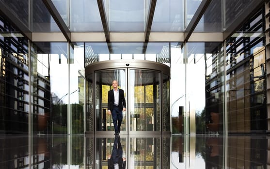 Business man walking out of office buildings. Copy space. Lifestyle and business concept.