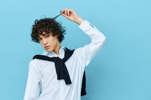 student in a white shirt sweater on the shoulders blue background. High quality photo