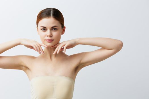 young woman bare shoulders pure skin glamor light background. High quality photo