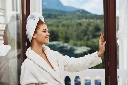 beautiful woman in a white robe on the balcony bit on green nature Relaxation concept. High quality photo