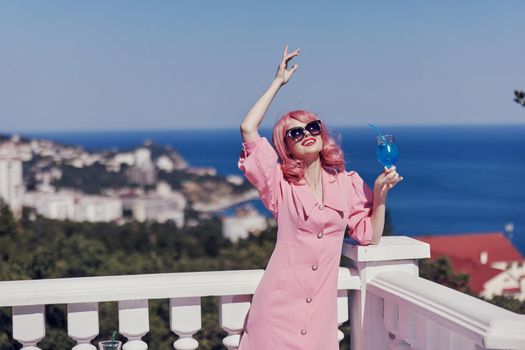 glamorous woman in a pink dress in sunglasses with a cocktail Relaxation concept. High quality photo