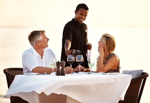 Shot of a mature couple enjoying a romantic dinner on the beach.