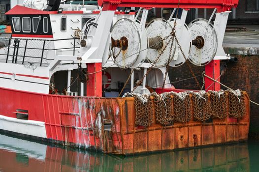 Red rusty boats and metal nets for catching scallops