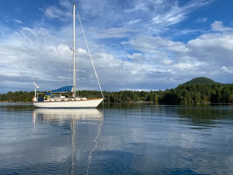 Sailboat in a beautiful and peaceful cove with blue skies. Located in Winter Cove, Gulf Islands National Marine Park