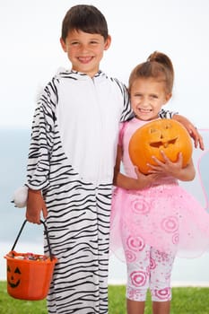 Portrait of two cute kids dressed up for Halloween.