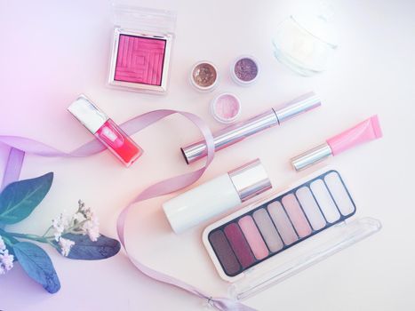 set of beauty cosmetics for female face and eye makeup on pink background . photo