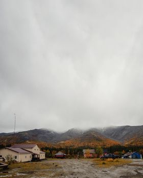 A gray autumn day at the KSS base in the Khibiny. Houses and cars against the backdrop of autumn mountains. photo