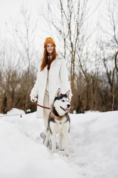 portrait of a woman outdoors in a field in winter walking with a dog fresh air. High quality photo