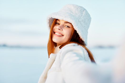 young woman in a white coat in a hat winter landscape walk travel. High quality photo