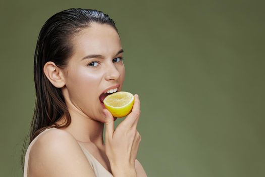 young woman lemon vitamins health cosmetology green background. High quality photo