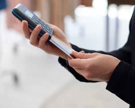 Closeup shot of an unrecognisable woman using a credit card machine in a store.