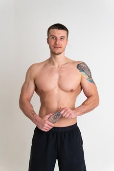Male drink-water fitness is pumped with a towel on a white background isolated fitness athlete health, exercise sportswear guy, athletic. protein perfect, thirsty one muscle