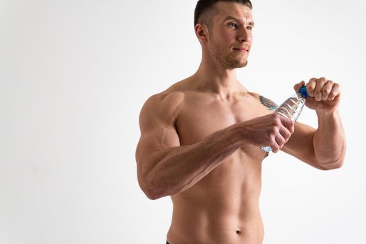 Male drink-water fitness is pumped with a towel on a white background isolated strong athlete lifestyle, training sport energy nutrition person, break cardio. protein caucasian one muscle