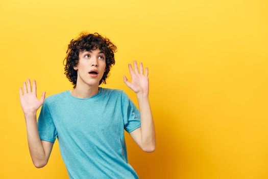 man in blue t-shirt shocked on yellow background. High quality photo