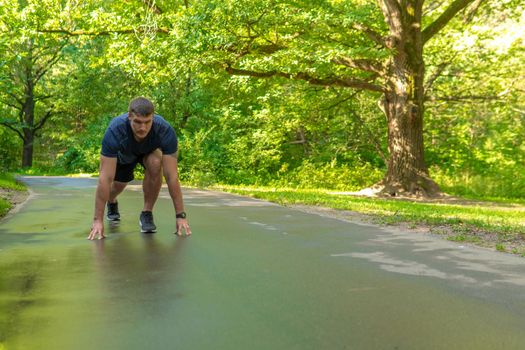 A man athlete runs in the park outdoors, around the forest, oak trees green grass young enduring athletic athlete run sport fitness jogger fit recreation wellbeing. Autumn leisure cross, runners stretches