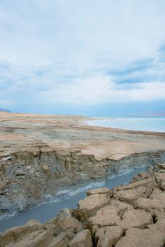 Sinkhole filled with turquoise water, near Dead Sea coastline. Hole formed when underground salt is dissolved by freshwater intrusion, due to continuing sea-level drop. . High quality photo