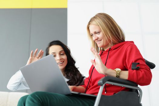 Portrait of women greeting family via online video call using laptop, woman visit friend in wheelchair at nursing home. Bff, meeting, happiness concept