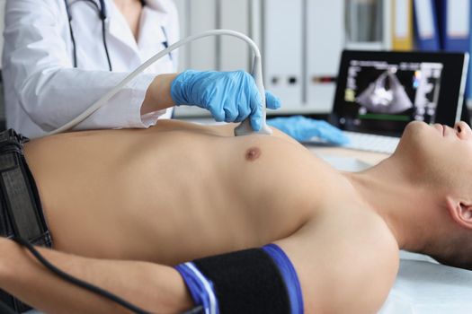 Portrait of doctor investigating male body, medical worker watch on screen with live picture. Person on planned checkup in hospital. Ultrasound concept