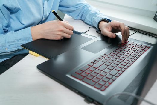 Graphic designer using digital tablet and computer in office