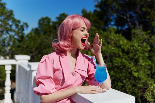cheerful woman with pink hair summer cocktail refreshing drink Happy female relaxing. High quality photo