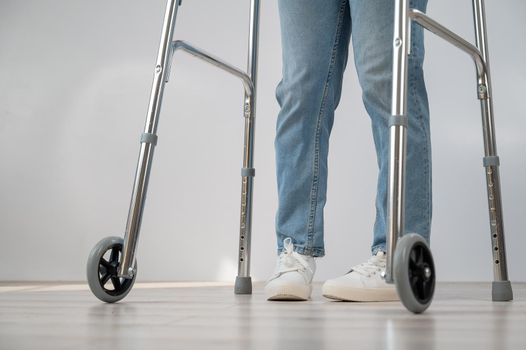 Close-up of female legs with walkers. The girl walks with the help of special equipment