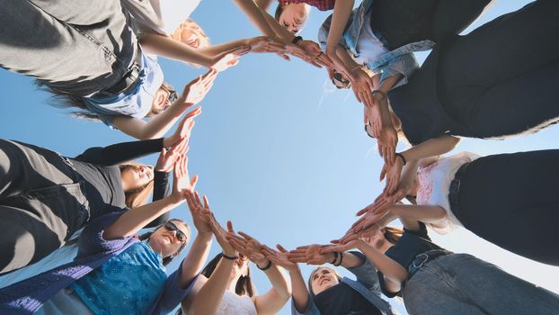 A group of girls makes a circle from their palms hands