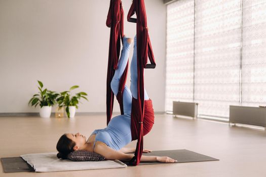 Pregnant girl. A woman does yoga on a hammock in the gym. The concept of a healthy lifestyle, Motherhood.