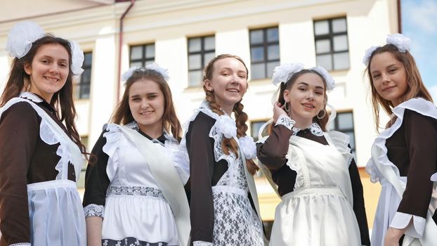 Smiling female graduates pose on the last day of school life