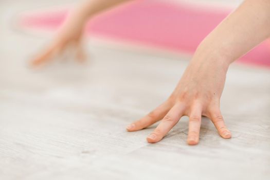 Girl does yoga. Young woman practices asanas on a beige one-ton background