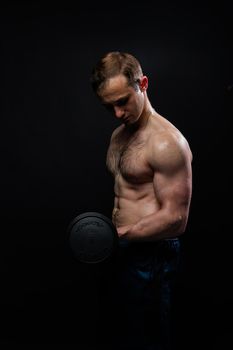 Man on black background keeps dumbbells pumped up in fitness active sexy black, body muscular man bodybuilder powerful, male sportive power, gym fit View from the bottom up good press beautiful muscles hairy chest charisma