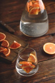 Infused water with bloody oranges in drinking glass