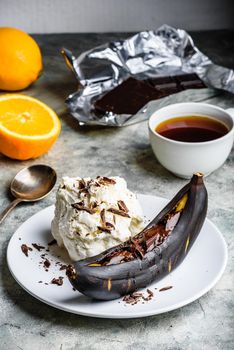 Sweet dessert. Grilled banana with dark chocolate, citrus juice and vanilla ice cream.