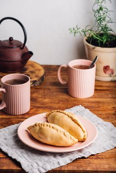 Two Homemade Cabbage Mini Pies on Plate and Mugs with Tea